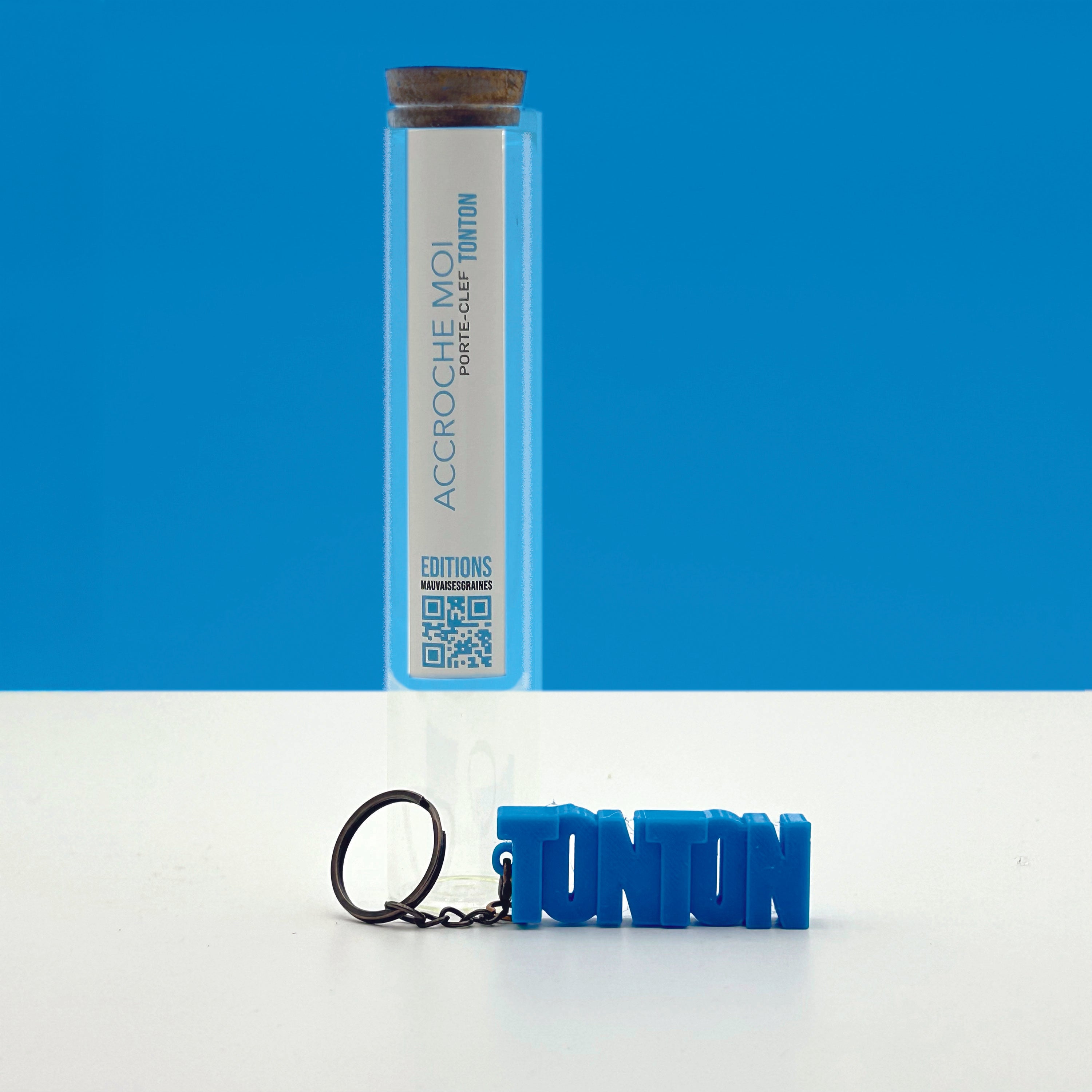 Porte-clés à message « Tonton», imprimé en 3D, présenté dans un tube à essai.