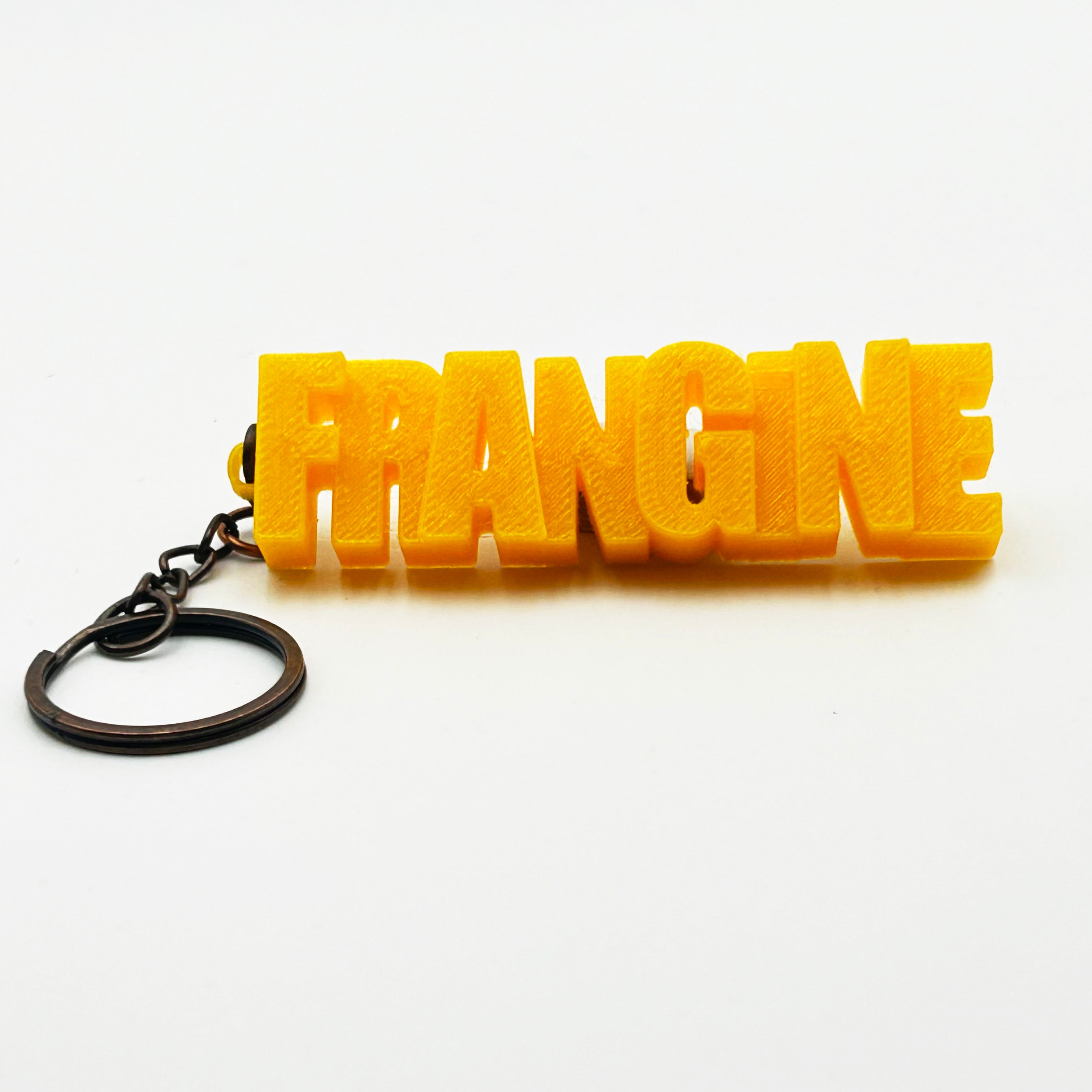 Porte-clés à message «Frangine », imprimé en 3D, présenté dans un tube à essai.