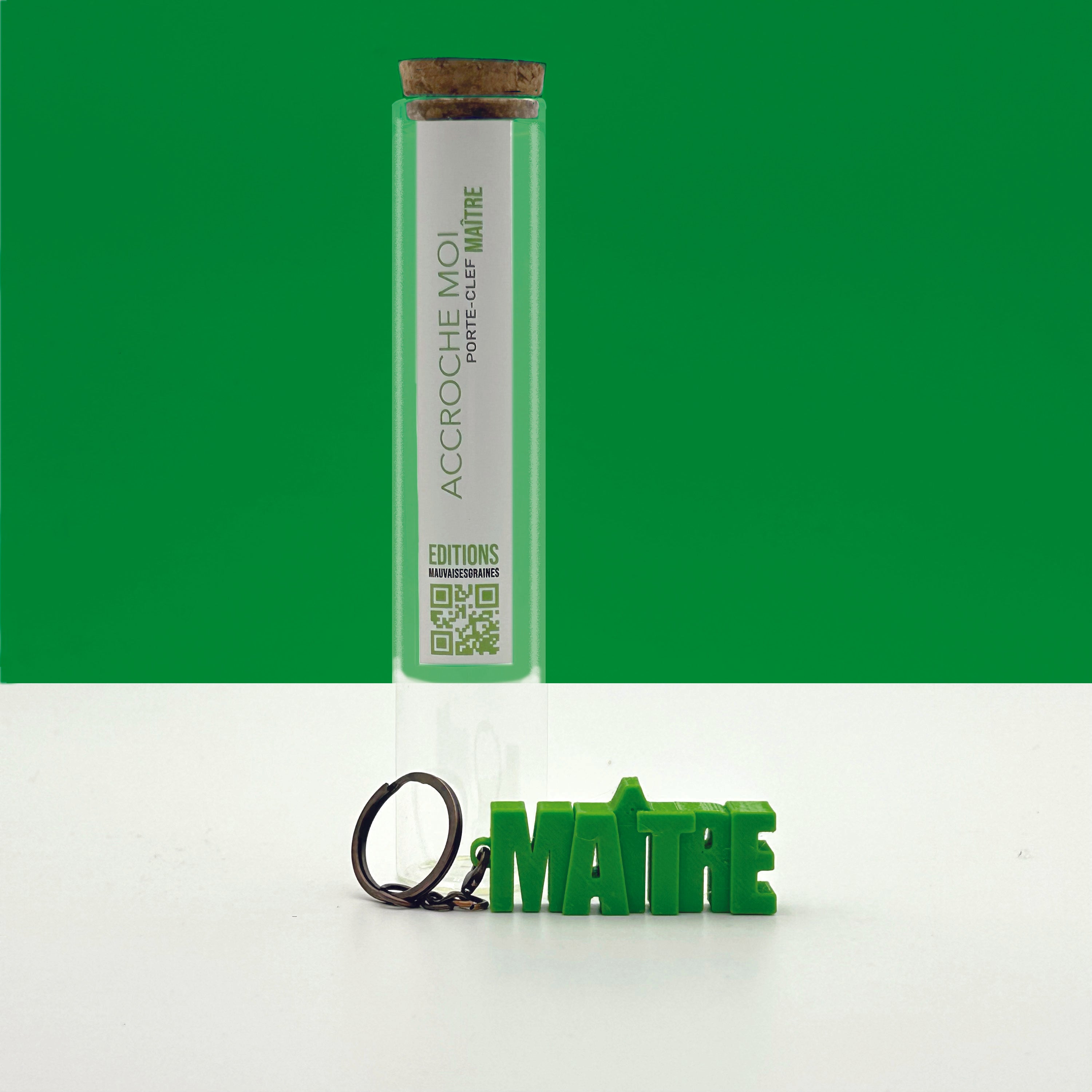 Porte-clés à message « Maître», imprimé en 3D, présenté dans un tube à essai.