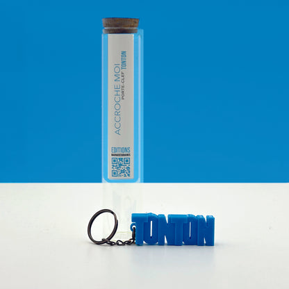 Porte-clés à message « Tonton», imprimé en 3D, présenté dans un tube à essai.