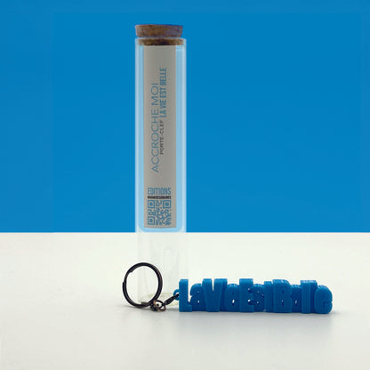 Porte-clés à message « La vie est belle », imprimé en 3D, présenté dans un tube à essai.