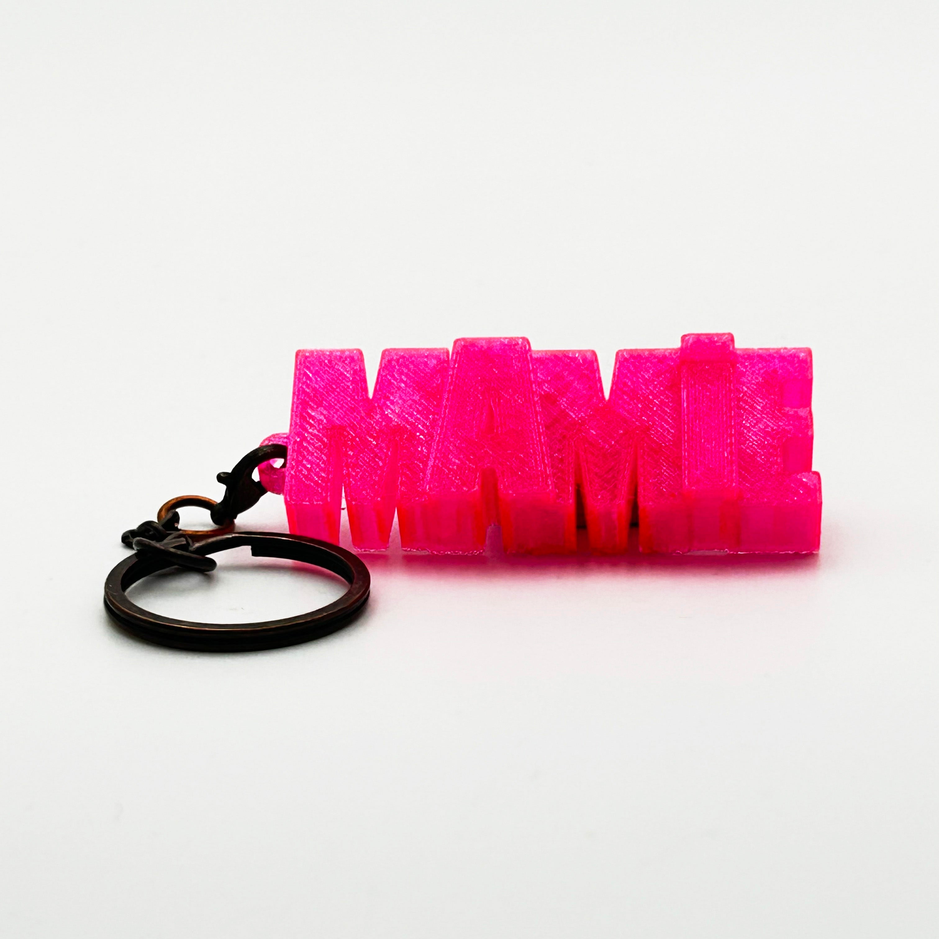 Porte-clés à message « Mamie», imprimé en 3D, présenté dans un tube à essai.