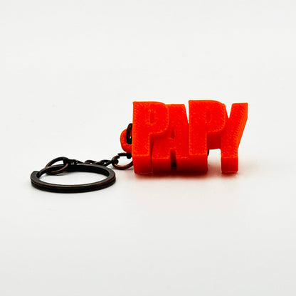 Porte-clés à message « Papy », imprimé en 3D, présenté dans un tube à essai.