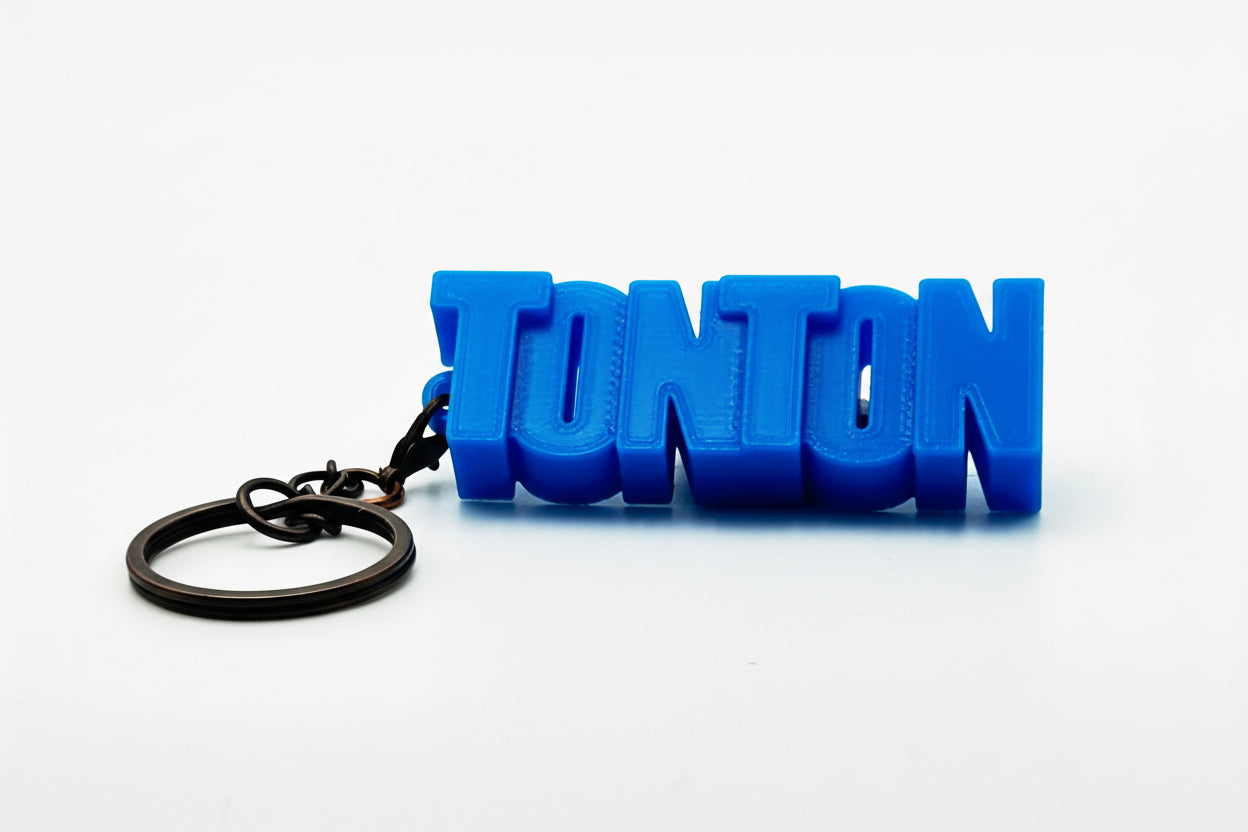 Porte-clés à message « Tonton», imprimé en 3D, présenté dans un tube à essai.
