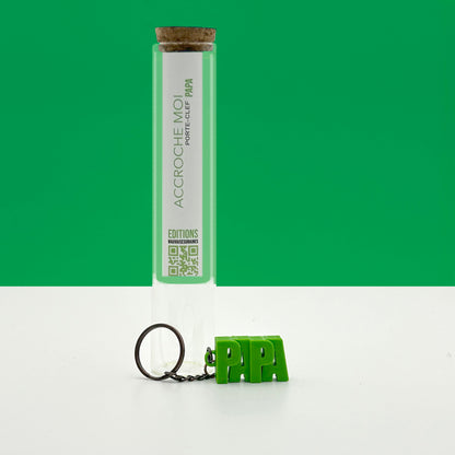 Porte-clés à message « PAPA», imprimé en 3D, présenté dans un tube à essai.