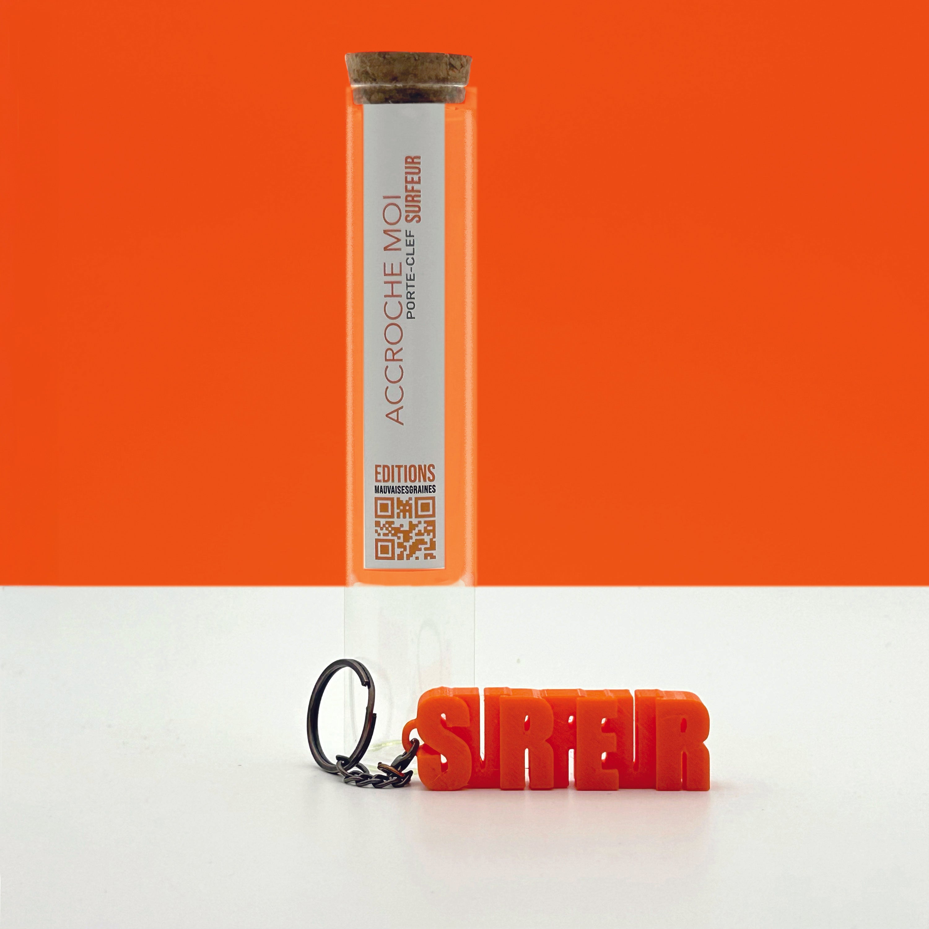 Porte-clés à message « Surfeur», imprimé en 3D, présenté dans un tube à essai.